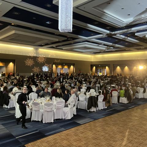 The Grand Ballroom filled with people eating at round tables at RBC Place London during Christmas at our Place 2024 - London's best holiday party for businesses is back on November 28, 2026
