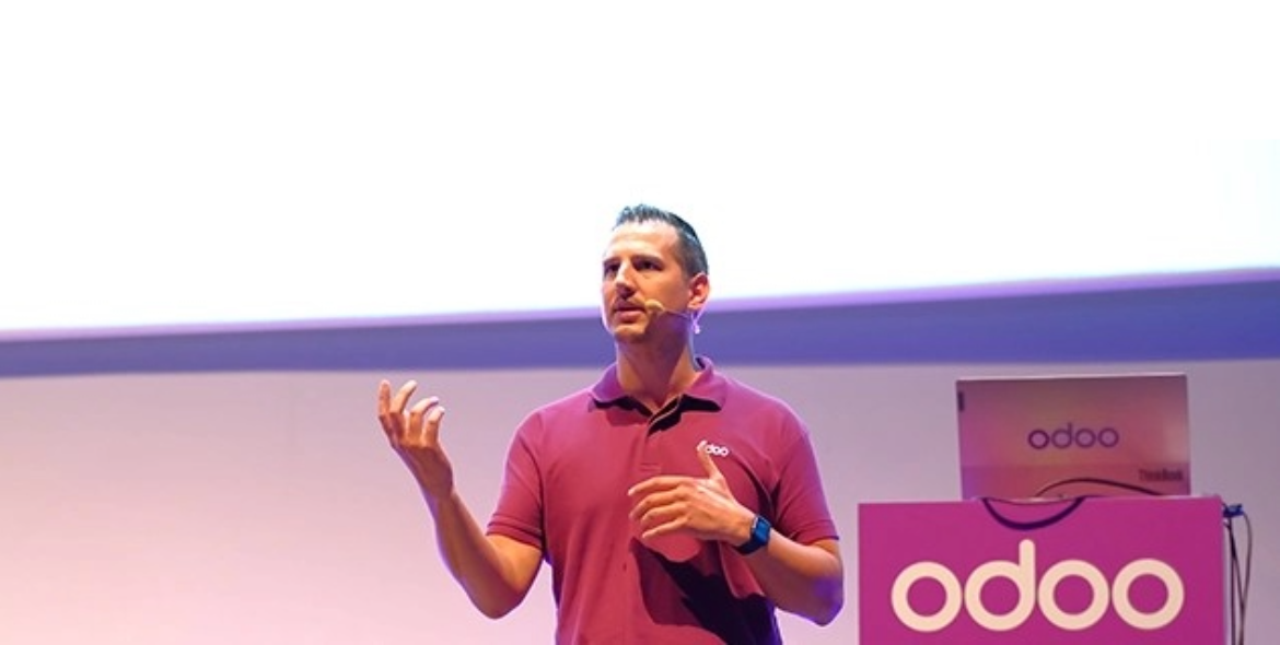 A speaker talks in front of a screen at an Odoo Business Show