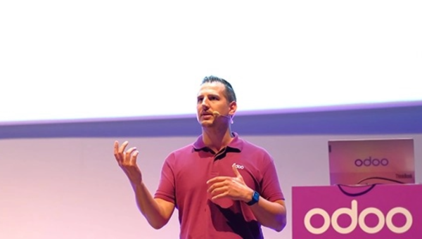 A speaker talks in front of a screen at an Odoo Business Show